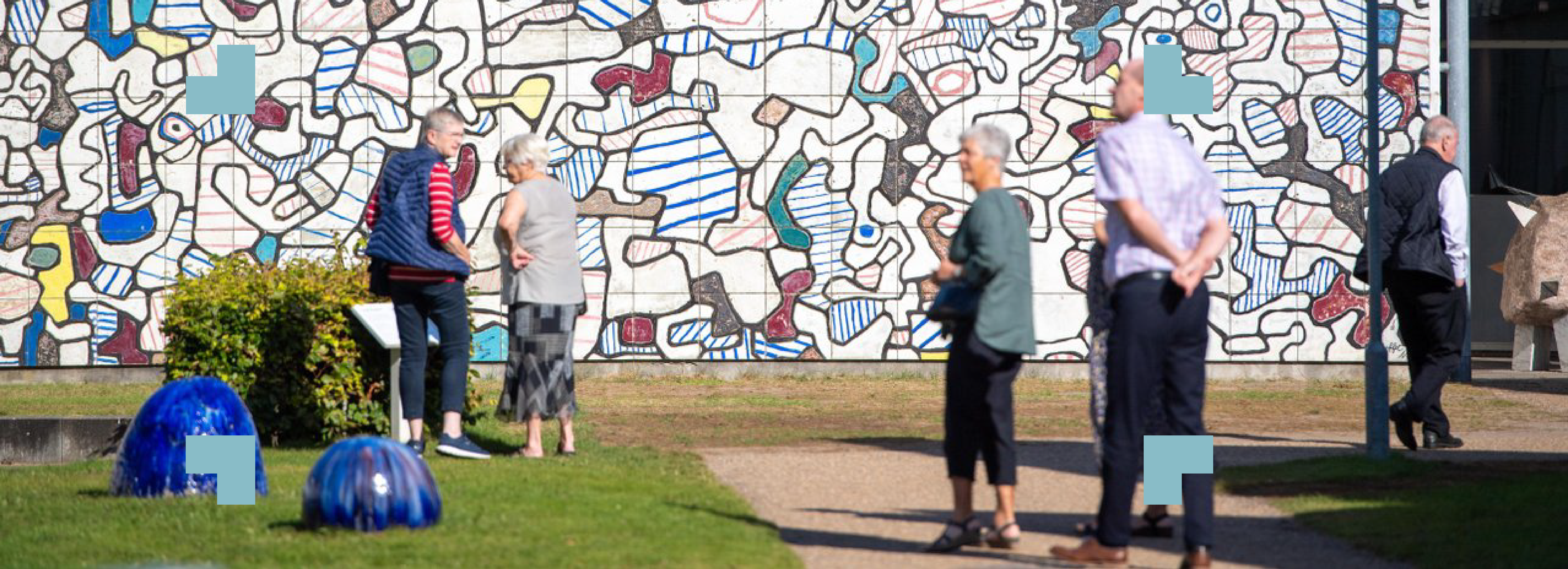 Mennesker ser på en mur med kunsttegninger