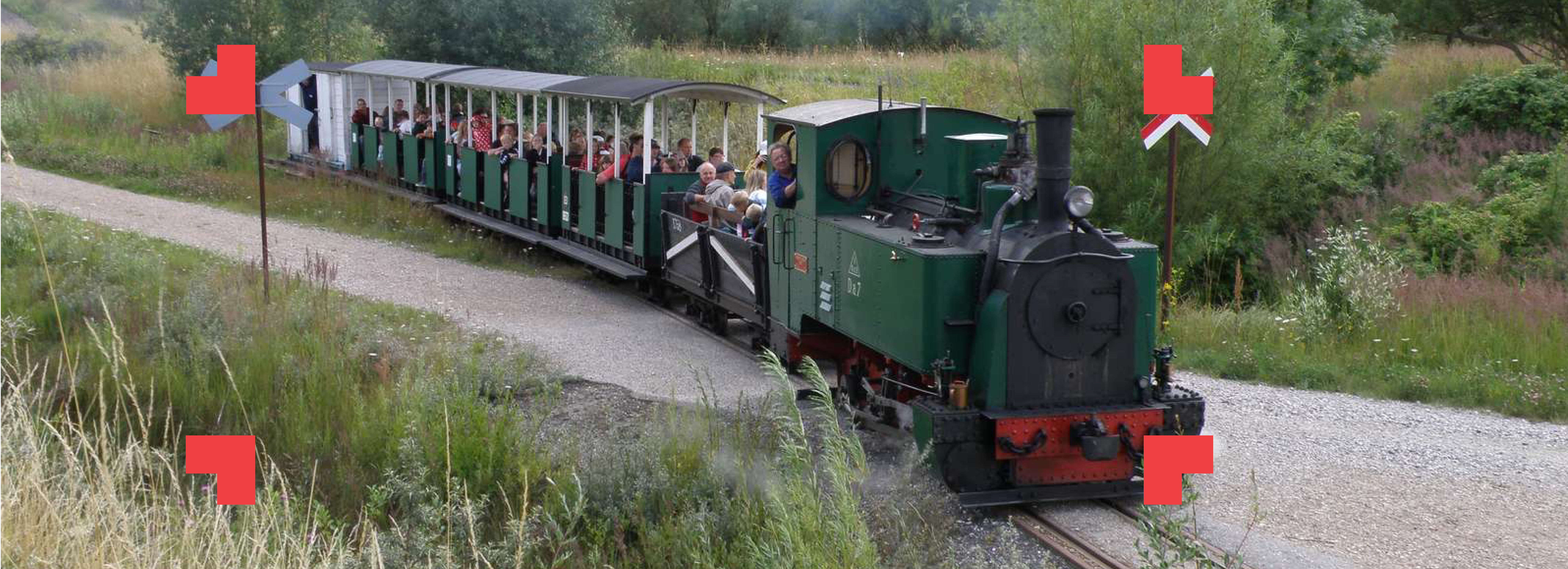 Turisttog med passagerer i åbent landskab