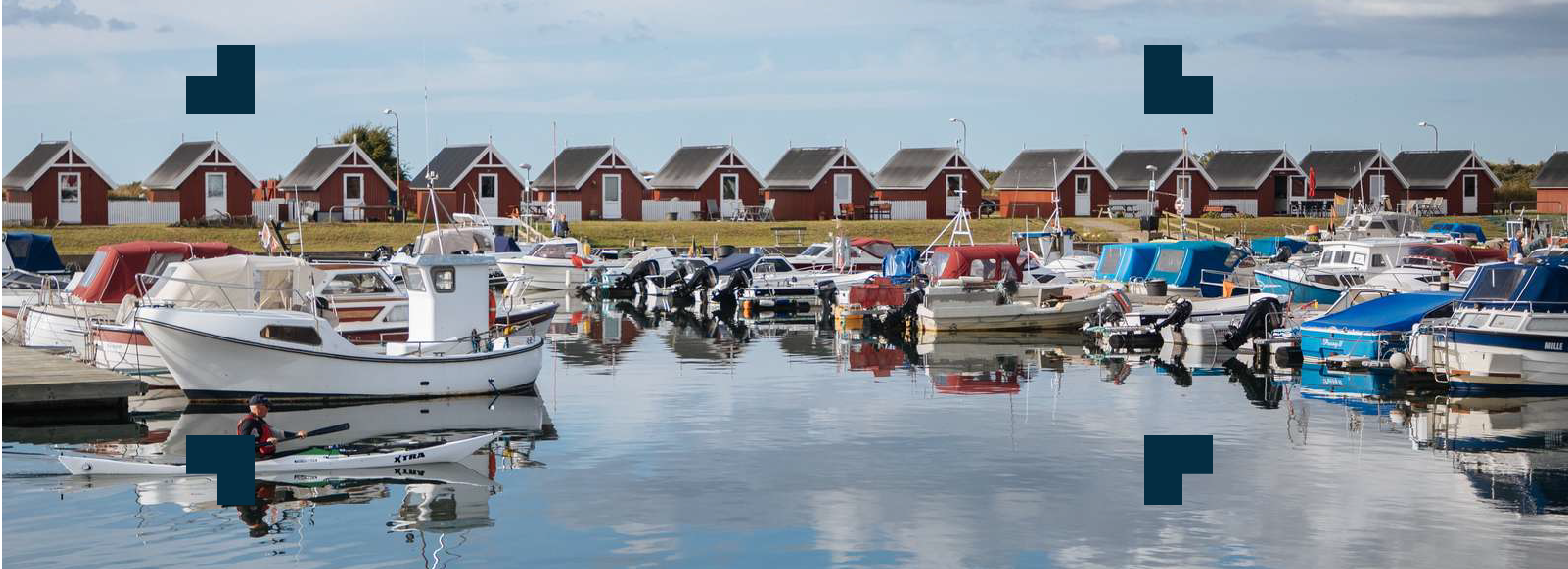 Lystbådehavn med lystbåde og små røde huse