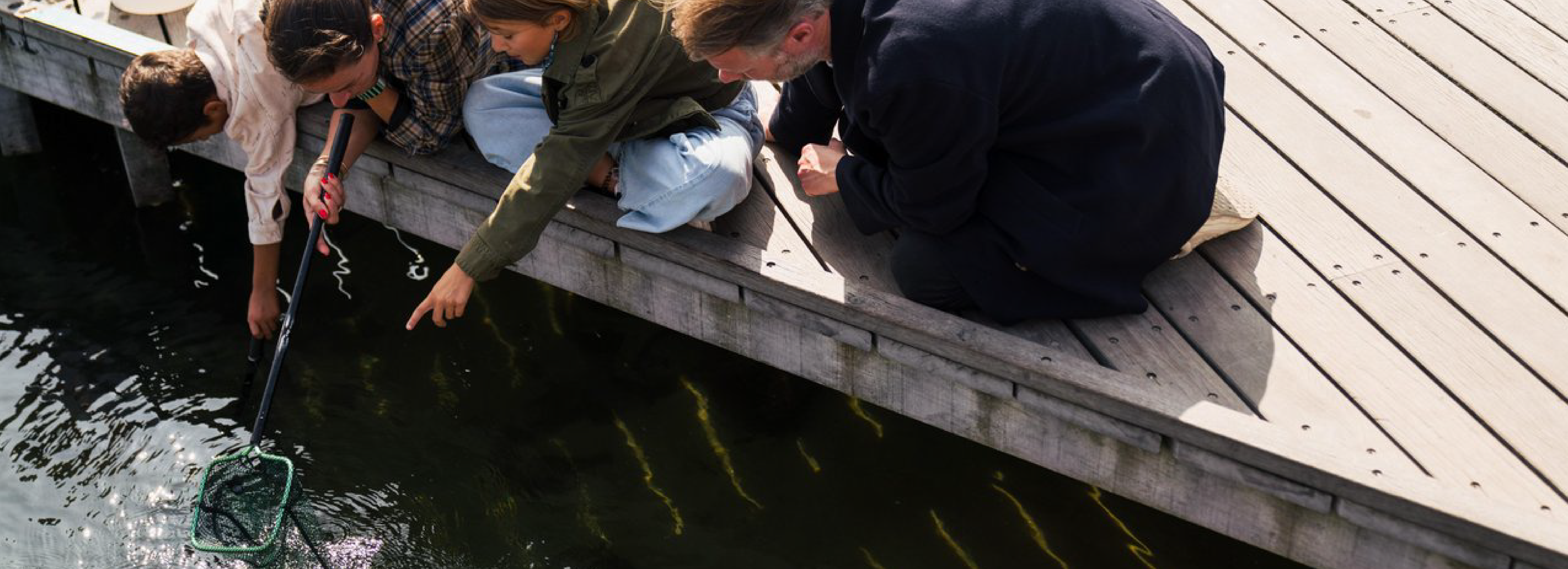 familie fisker med net fra mole